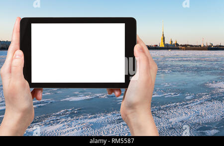 travel concept - tourist photographs of ice covered Neva river and Peter and Paul Fortress in Saint Petersburg city in March on smartphone with empty  Stock Photo