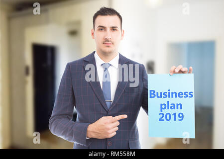 Man using index finger for pointing at blue paper with business plan for year as profit strategy concept Stock Photo