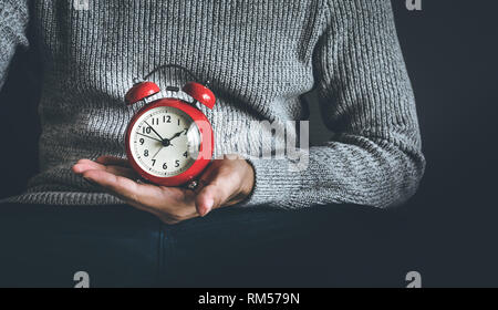 Time and life concepts with young man holding alarm clock and sitting on sofa.Motivation images ideas Stock Photo