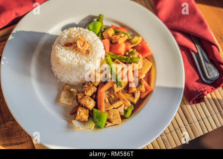 Traditional Balinese cuisine. Vegetable and tofu stir-fry with rice Stock Photo