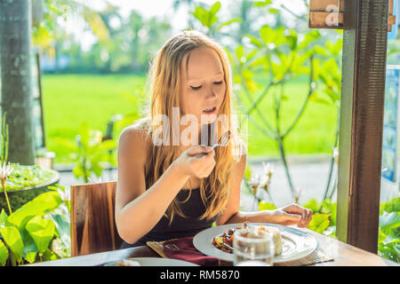 Woman eating Traditional Balinese cuisine. Vegetable and tofu stir-fry with rice Stock Photo