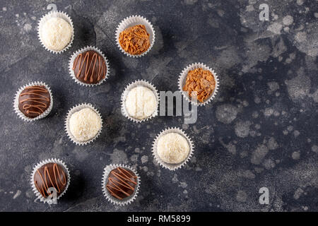 Rows of homemade chocolate sweets collection in a dark background. Stock Photo