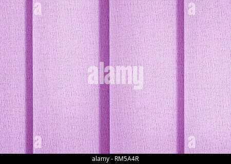 Pink blinds vertical blinds in full screen. Close-up of textile surface texture. Protection from sunlight on the window. Stock Photo