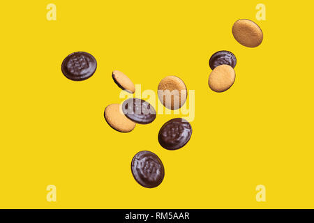 Flying Food Concept Group of Sweet Chocolate Digestive Biscuits in the Air on Yellow Background Stock Photo