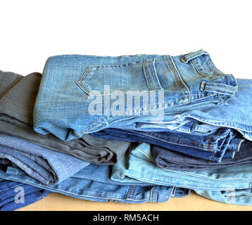 Many fashionable youth jeans lie in a mess isolated on white background Stock Photo