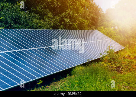 Close-up surface of lit by sun modern saving efficient stand -alone blue shiny solar photo voltaic panels system producing renewable clean energy on g Stock Photo