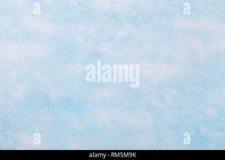 Construction of a light blue background with white spots of felt fabric, closeup. Texture of sky woolen matt textile. Cloth backdrop. Stock Photo