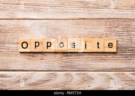 Opposite word written on wood block. Opposite text on wooden table for your desing, concept. Stock Photo