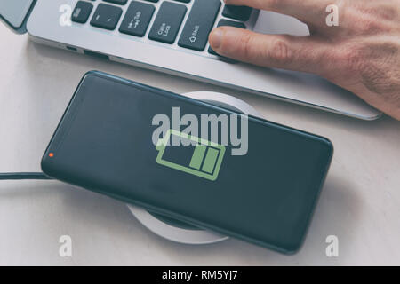 Smartphone on a wireless charging pad, charger. Stock Photo