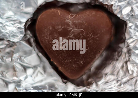 Chocolate heart on wrapping paper Stock Photo