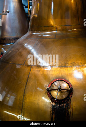 Old copper whisky pot still showing the opening hatch at the Balblair whisky distillery, Edderton, Ross-shire, Scotland Stock Photo