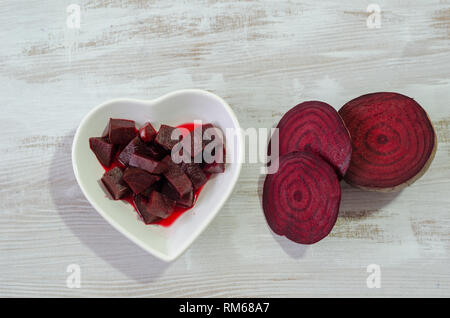 Slices of beets and boiled beet are on wooden table.Top view Stock Photo