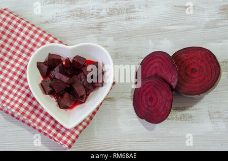 Slices of beets and boiled beet are on wooden table.Top view Stock Photo