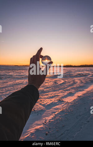 Winter sunset with glass sphere. Stock Photo