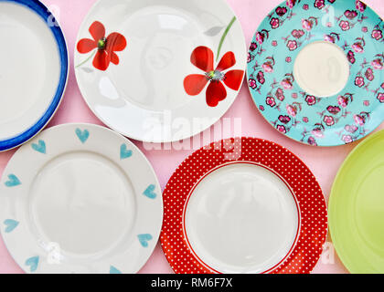 A selection of six pretty tea plates against a pink background taken from an overhead view Stock Photo