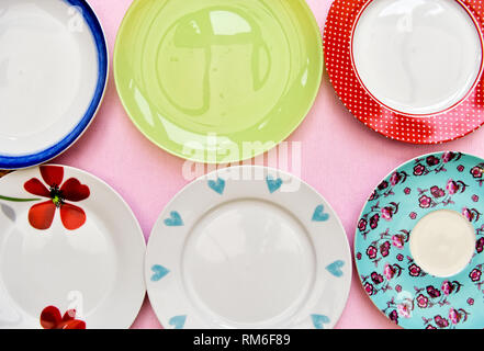 A selection of six pretty tea plates against a pink background taken from an overhead view Stock Photo