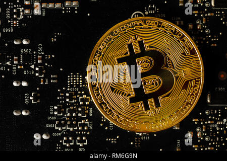 Dark gold bitcoin on crypto mining GPU circuit board computer hardware Stock Photo