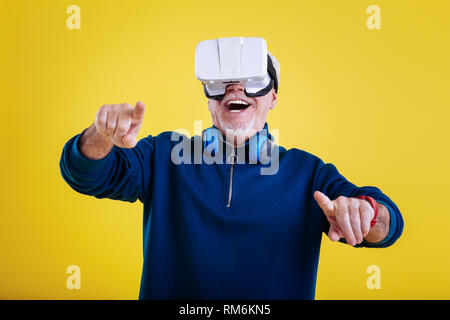 Retired man feeling cheerful wearing VR glasses for the first time Stock Photo