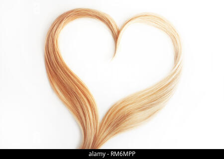 Strand of blond hair isolated on white. Curls of hair in the shape of a heart, health and hair care concept. Stock Photo