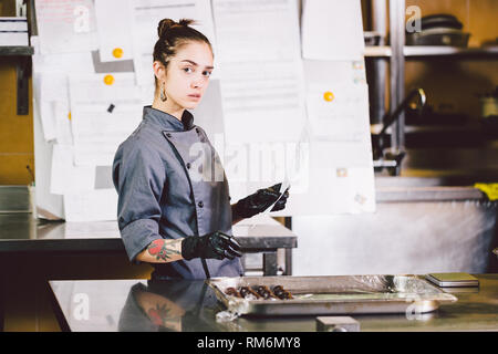 Free Photos - A Young, Bold, And Beautiful Woman With Tattoos On Her Arm,  Who Is A Chef. She Is Standing In A Kitchen With A Smile On Her Face,  Wearing An