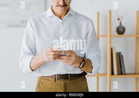cropped view of senior man using smartphone at home Stock Photo