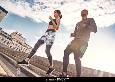 Exercising on fresh air. Portrait of a young sports couple doing morning workout on a sunny and warm day. Healthy couple. Sport motivation concept. Fitness concept. Women beauty. Healthy life. Exercising together. Active morning. common hobbies Stock Photo