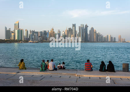 Doha, Qatar - November 4, 2016. Al Corniche waterfront in Doha, with families enjoying late afternoon and skyscrapers in the background. Stock Photo