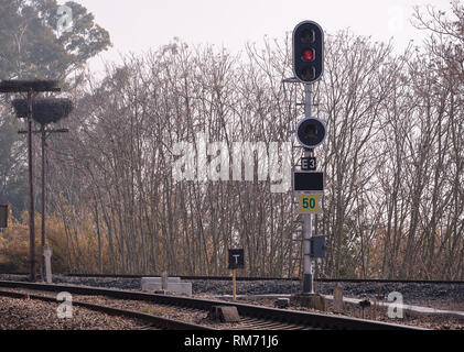 Semaphore view of entrance to railway station with storks nests in the background Stock Photo