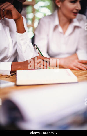 Selective focus on woman hand writing in notebook Stock Photo