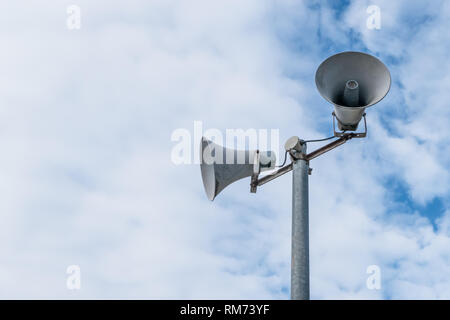 Old loud speakers isolated on the blue sky background with white clouds. Space for text. Stock Photo