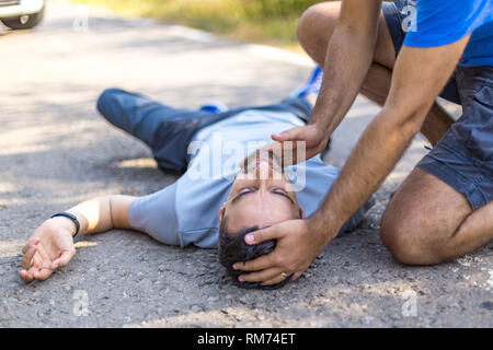 First aid doing CPR. Person offers the First aid doing CPR after the car accident Stock Photo