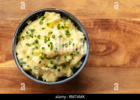 Pomme puree, an overhead photo of a bowl of mashed potatoes with herbs, shot from the top on a rustic wooden background with copy space Stock Photo