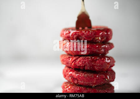 Pyramid of heesecakes with honey colored in red. Russian traditional breakfast.Food consept.Plate with puncakes on white marble background.Copyspace f Stock Photo