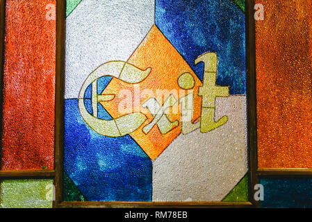 Exit word in an antique engraving on the colorful glass of a door. Stock Photo