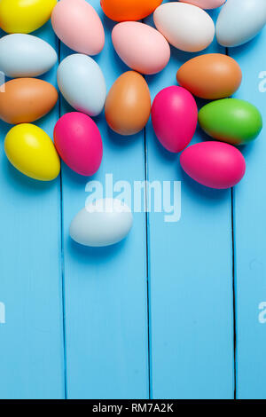 Colorful Easter egg side border against a blue wood background Stock Photo
