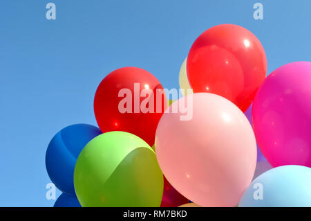 multicolored balloons in the city festival on blue sky background Stock Photo