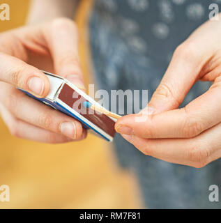 Girl playing with matches. Dangerous situation at home. Stock Photo