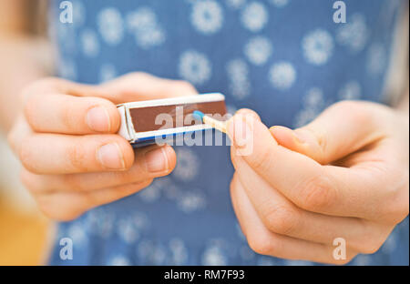 Girl playing with matches. Dangerous situation at home. Stock Photo