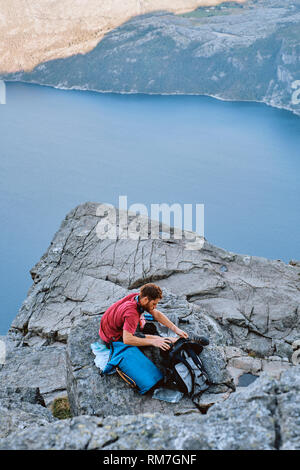 A lone man wild camping on top of the Pulpit Rock / Preikestolen or Prekestolen in Ryfylke in Rogaland Norway Stock Photo