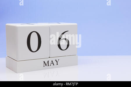 May 06st. Day 6 of month, daily calendar on white table with reflection, with light blue background. Spring time, empty space for text Stock Photo
