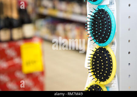 Colored hair brushes are sold. Combs for hair on a stand in a supermarket with copy space Stock Photo