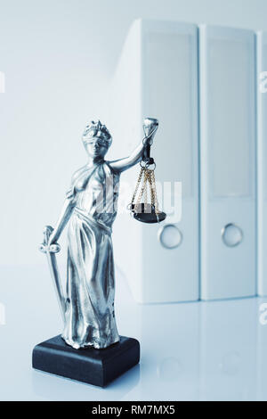 Lady Justice statue with document ring binders in law office Stock Photo