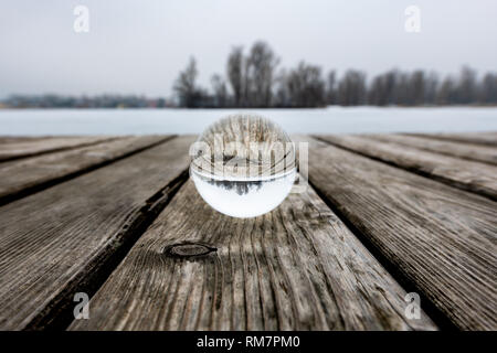 Glass sphere on a public bathing place in winter, frozen water (Vienna, Austria) Stock Photo