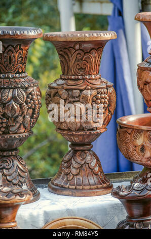 Geghard, Armenia, September 20, 2018:Wooden vase carved in the traditional style with a pattern of grapes and pomegranate on a branch with leaves and  Stock Photo