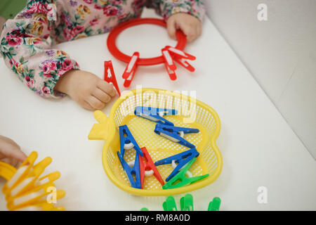 Toddlers playing multicolored educational games, mosaic and puzzles table. Stock Photo