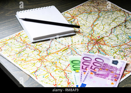 Close up of map, money, blank canvas notepad and pencil. Traveller equipment or set concept. Packing things for travelling. Making plans for travel. Stock Photo
