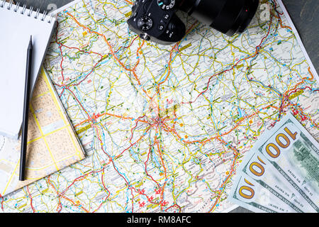 Close up of maps, money, camera, blank canvas notepad and pencil. Traveller equipment or set concept. Packing things for travelling. Making plans for  Stock Photo