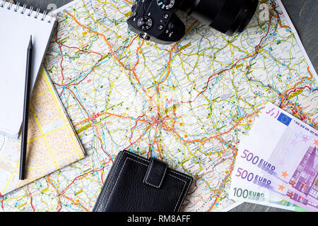 Close up of maps, money, wallet, camera, blank canvas notepad and pencil. Traveller equipment or set concept. Packing things for travelling. Making pl Stock Photo
