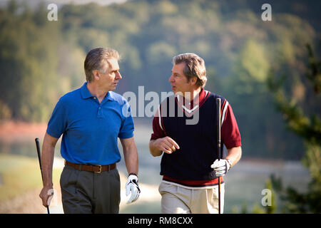 Two mature men enjoying a game together on a golf course. Stock Photo