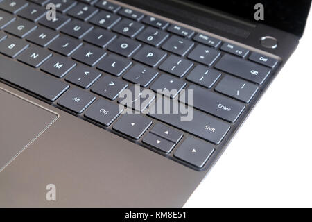 Part of opened laptop with keyboard, touchpad and empty mirror screen of black opened laptop isolated on white background side view closeup Stock Photo